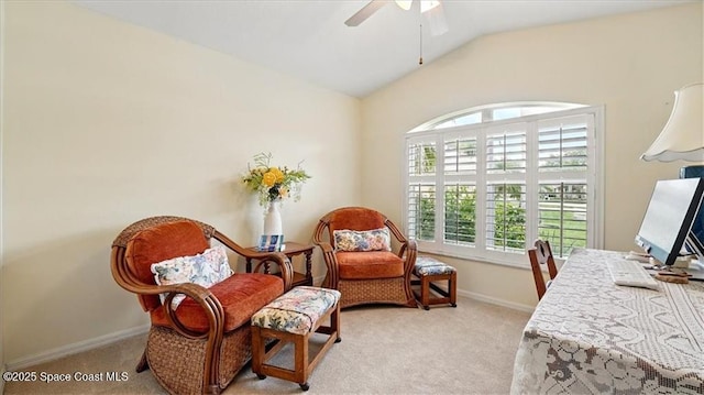 sitting room with vaulted ceiling, baseboards, light colored carpet, and ceiling fan