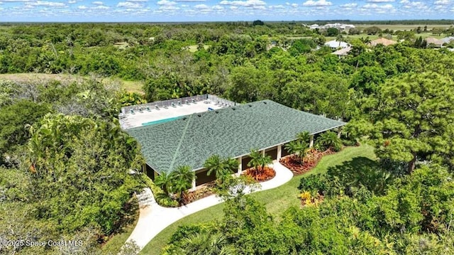 drone / aerial view featuring a forest view