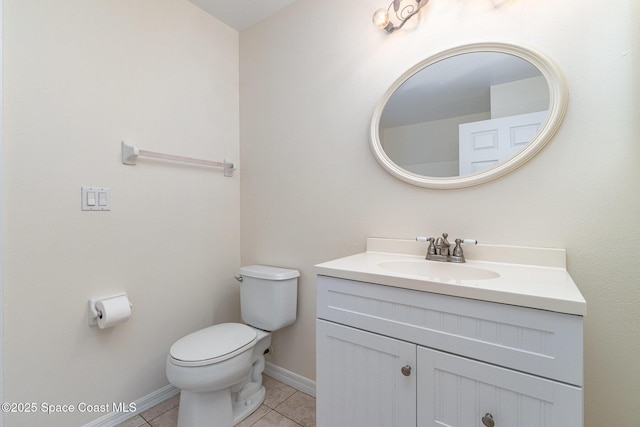 half bathroom with tile patterned flooring, toilet, vanity, and baseboards