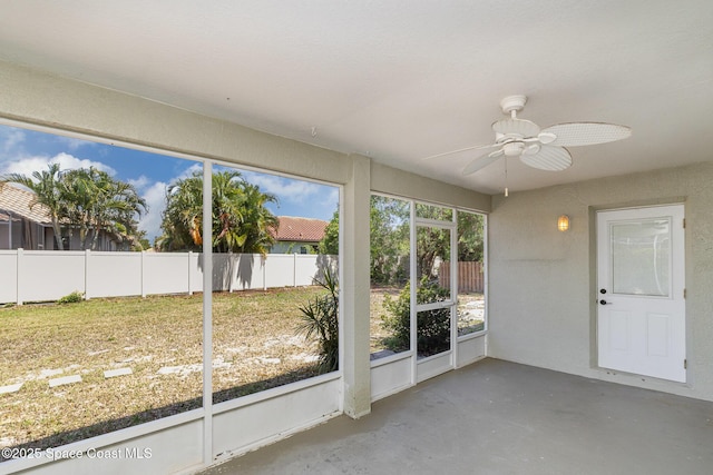 unfurnished sunroom featuring a ceiling fan