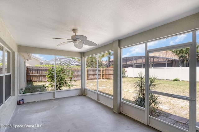 unfurnished sunroom with ceiling fan and plenty of natural light