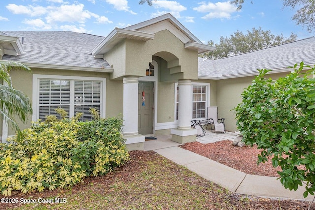 6109 Meghan Dr, Melbourne, FL 32940 - property entrance featuring a shingled roof and stucco siding