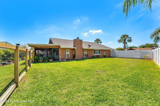 3210 Calgary St, Melbourne, FL 32935 - rear view of house with a sunroom, a yard, a fenced backyard, and a chimney