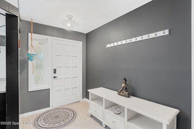 3210 Calgary St, Melbourne, FL 32935 - foyer entrance with light tile patterned floors, baseboards, and a textured ceiling