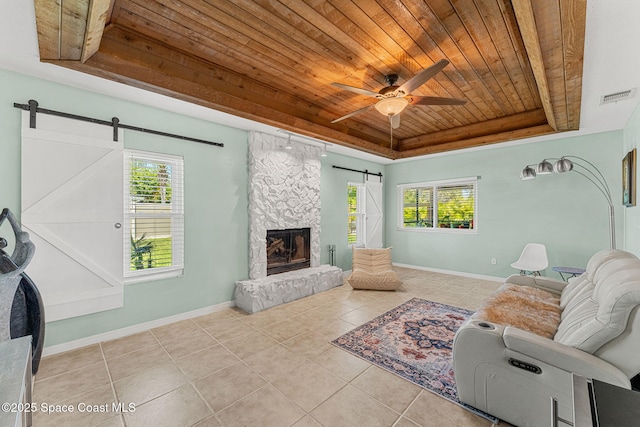 3210 Calgary St, Melbourne, FL 32935 - tiled living room featuring ceiling fan, visible vents, a barn door, wood ceiling, and a raised ceiling
