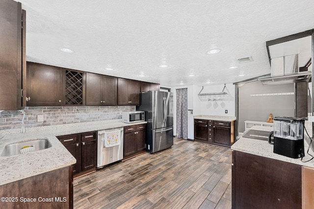 3210 Calgary St, Melbourne, FL 32935 - kitchen featuring dark brown cabinetry, visible vents, dark wood finished floors, stainless steel appliances, and a sink
