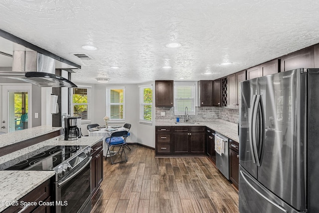 3210 Calgary St, Melbourne, FL 32935 - kitchen featuring appliances with stainless steel finishes, dark brown cabinetry, light stone counters, dark wood finished floors, and a sink