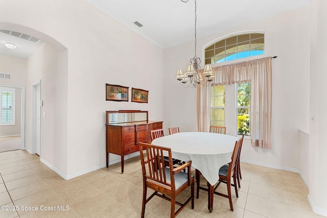dining space with light tile patterned floors, a chandelier, baseboards, and arched walkways