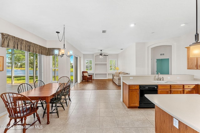 kitchen with light tile patterned flooring, light countertops, dishwasher, and a sink