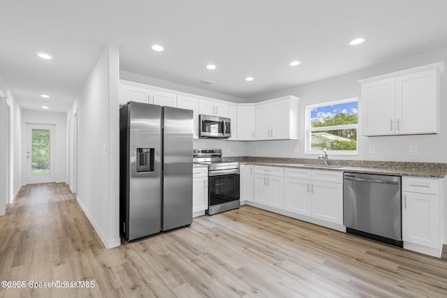 kitchen featuring white cabinetry, a sink, appliances with stainless steel finishes, and a healthy amount of sunlight