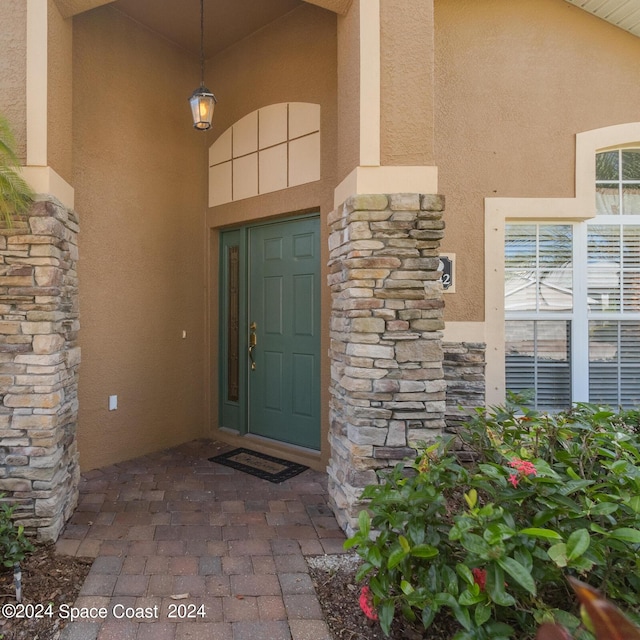 2842 Galindo Cir, Melbourne, FL 32940 - doorway to property featuring stone siding and stucco siding