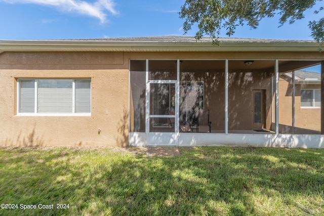 2842 Galindo Cir, Melbourne, FL 32940 - back of property with a lawn, stucco siding, and a sunroom