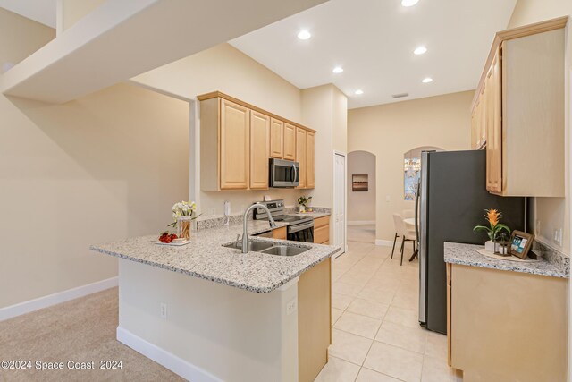 2842 Galindo Cir, Melbourne, FL 32940 - kitchen featuring a sink, appliances with stainless steel finishes, a peninsula, light brown cabinets, and arched walkways