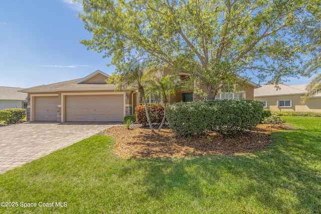 2842 Galindo Cir, Melbourne, FL 32940 - view of front of property with stone siding, decorative driveway, an attached garage, a front lawn, and stucco siding