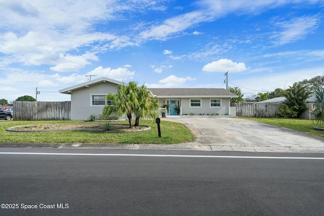 1117 Cheyenne Dr, Indian Harbour Beach, FL 32937 - ranch-style house with a front lawn, driveway, stucco siding, and fence