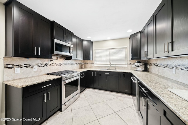 1117 Cheyenne Dr, Indian Harbour Beach, FL 32937 - kitchen featuring light tile patterned floors, stainless steel appliances, decorative backsplash, light stone counters, and dark cabinets