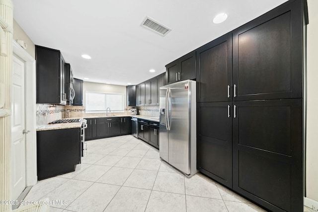 1117 Cheyenne Dr, Indian Harbour Beach, FL 32937 - kitchen featuring light countertops, tasteful backsplash, appliances with stainless steel finishes, light tile patterned floors, and visible vents