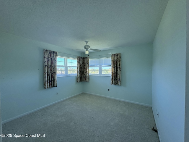 carpeted empty room with baseboards, a textured ceiling, and ceiling fan