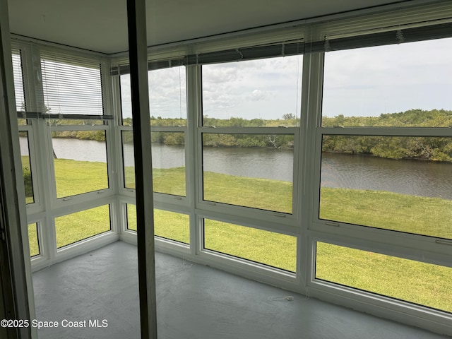 unfurnished sunroom featuring a water view