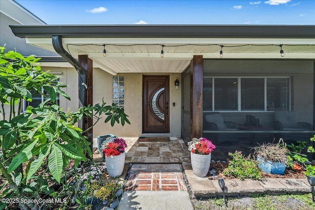 view of exterior entry with stucco siding