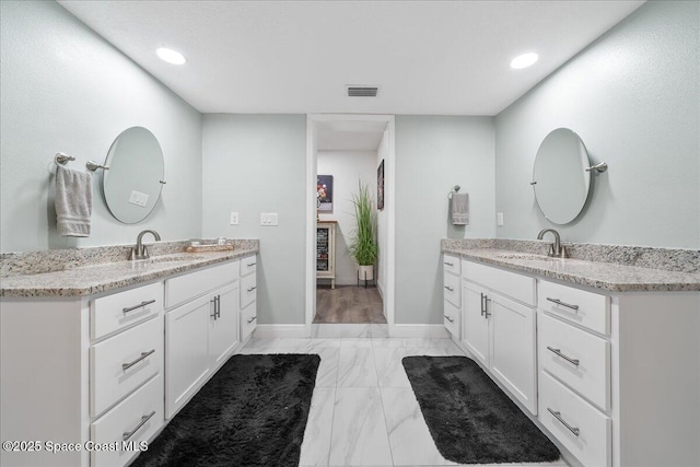 1253 Saint Andrews Dr, Rockledge, FL 32955 - bathroom featuring a sink, visible vents, two vanities, and marble finish floor