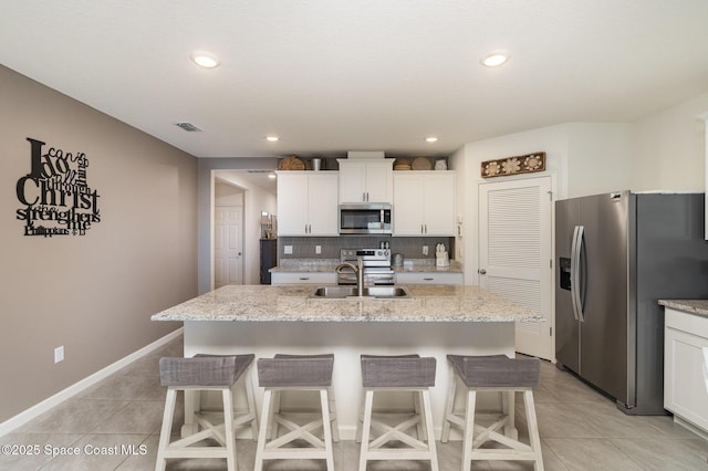 6575 Topaz Dr, Grant, FL 32949 - kitchen featuring tasteful backsplash, light tile patterned flooring, a kitchen island with sink, appliances with stainless steel finishes, and a sink