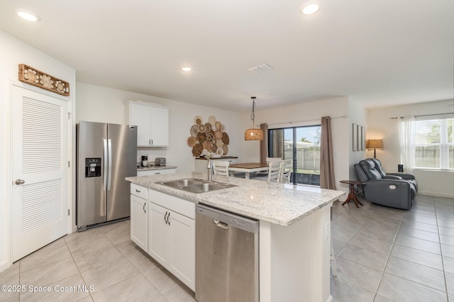 6575 Topaz Dr, Grant, FL 32949 - kitchen with an island with sink, white cabinetry, light tile patterned flooring, appliances with stainless steel finishes, and a sink
