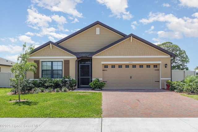 6575 Topaz Dr, Grant, FL 32949 - craftsman house with stucco siding, decorative driveway, a front yard, fence, and a garage