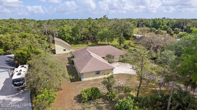 drone / aerial view with a wooded view