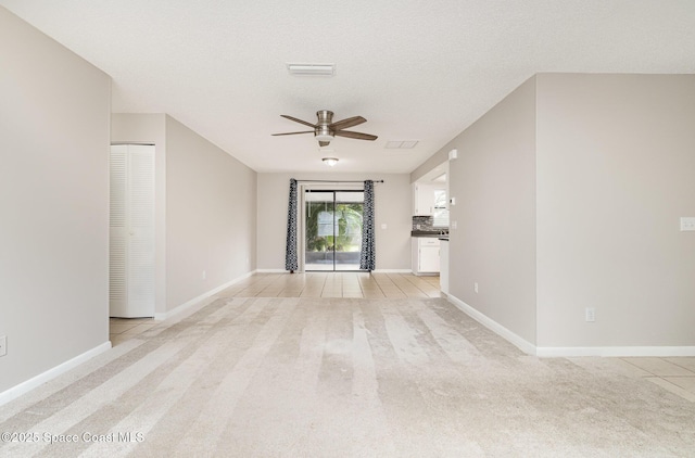 unfurnished living room featuring baseboards, a ceiling fan, and light colored carpet
