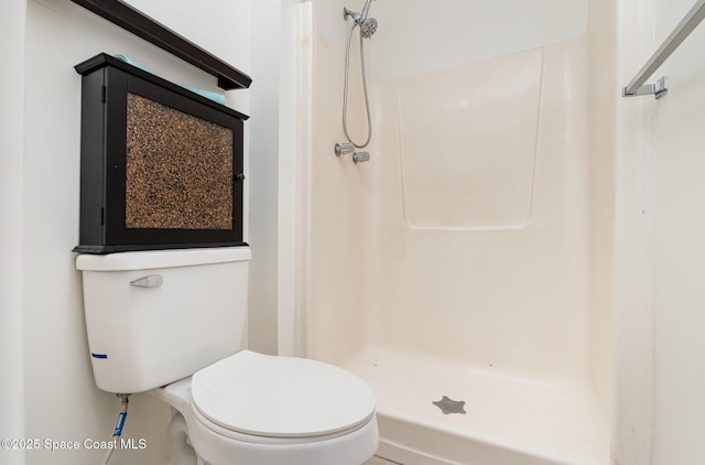 full bath featuring a shower stall and toilet