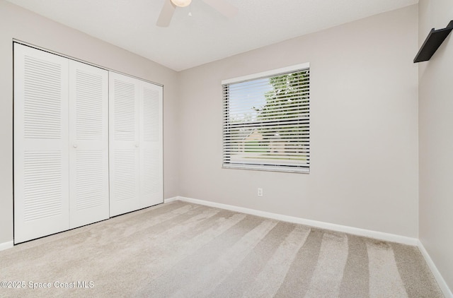 unfurnished bedroom featuring carpet floors, baseboards, a closet, and ceiling fan