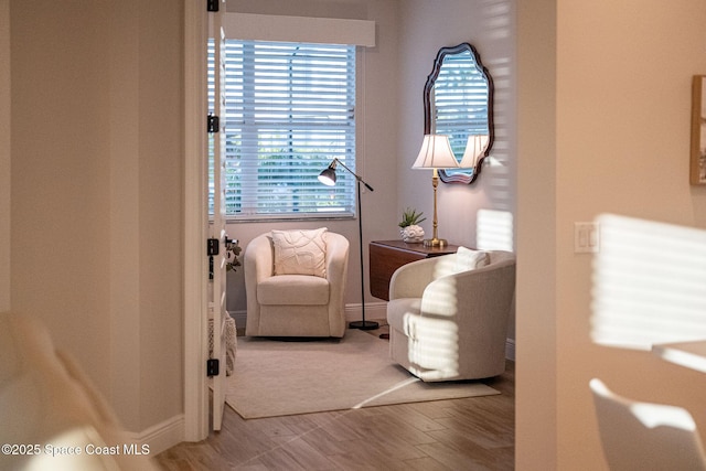 sitting room with baseboards and wood finished floors