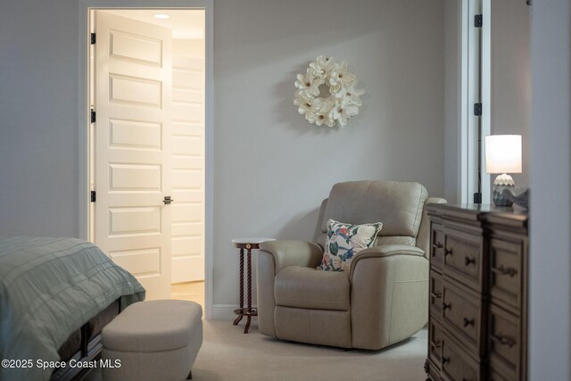 sitting room with baseboards and light colored carpet