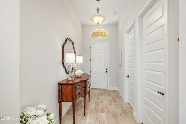 entrance foyer with baseboards and light wood-style floors