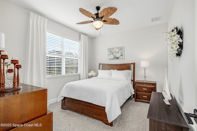 carpeted bedroom featuring baseboards, a ceiling fan, and visible vents