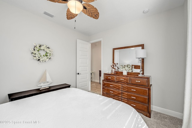 carpeted bedroom featuring visible vents, baseboards, and ceiling fan