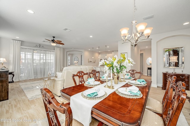 dining room featuring light wood finished floors, ceiling fan with notable chandelier, visible vents, and recessed lighting