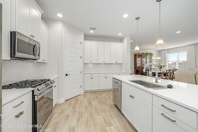 kitchen featuring stainless steel appliances, a sink, and recessed lighting