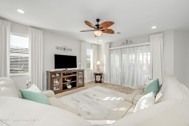 living room featuring recessed lighting, wood finished floors, visible vents, baseboards, and ceiling fan