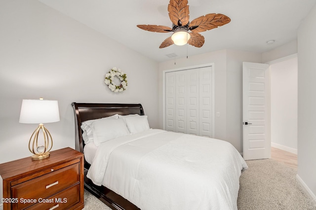 carpeted bedroom with a closet, a ceiling fan, and baseboards