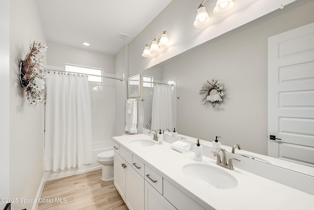 bathroom with toilet, a sink, visible vents, and double vanity
