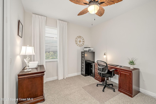 office space with a ceiling fan, baseboards, and light carpet