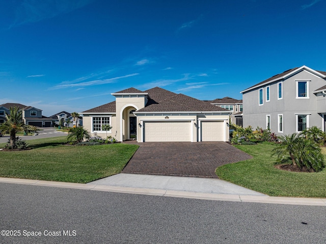 view of front of house with an attached garage, driveway, a front lawn, and stucco siding