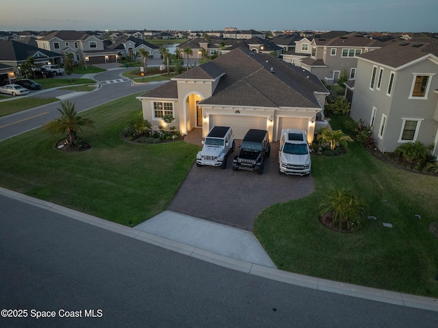 view of front facade with an attached garage, decorative driveway, a residential view, and a front lawn