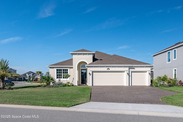 view of front facade with decorative driveway, a garage, a shingled roof, a front yard, and stucco siding