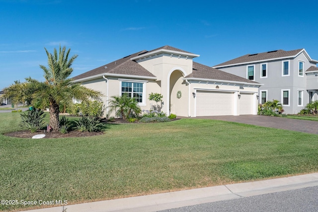 mediterranean / spanish-style home with aphalt driveway, a front lawn, stucco siding, an attached garage, and roof with shingles