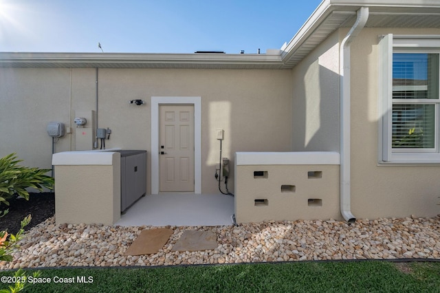 entrance to property with stucco siding