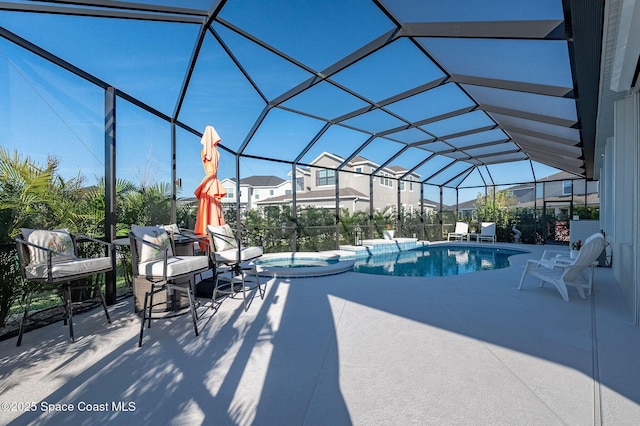 view of swimming pool with a patio area, glass enclosure, and a pool with connected hot tub