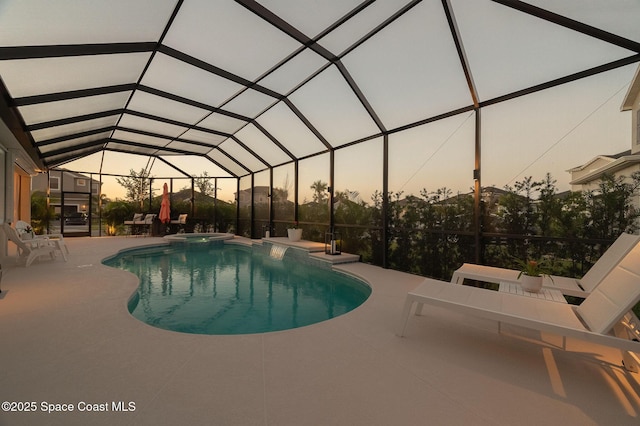view of swimming pool featuring glass enclosure, a patio area, and a pool with connected hot tub